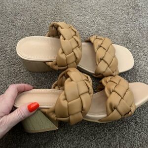 Beige heels with a woven strap.